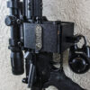 ARmA15 mount securing a vertical AR15 rifle to a wall with a padlock.